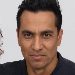 Joyful white adult male with short  black hair and brown eyes