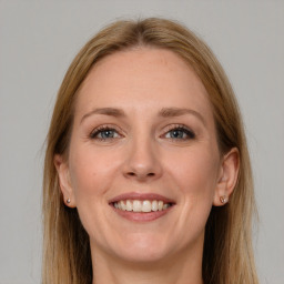 Joyful white adult female with long  brown hair and grey eyes