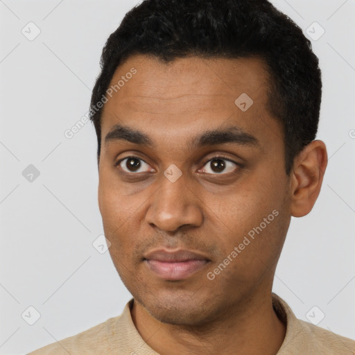 Joyful black young-adult male with short  black hair and brown eyes