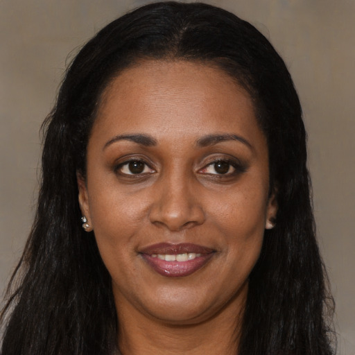 Joyful black adult female with long  brown hair and brown eyes
