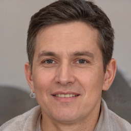 Joyful white adult male with short  brown hair and brown eyes