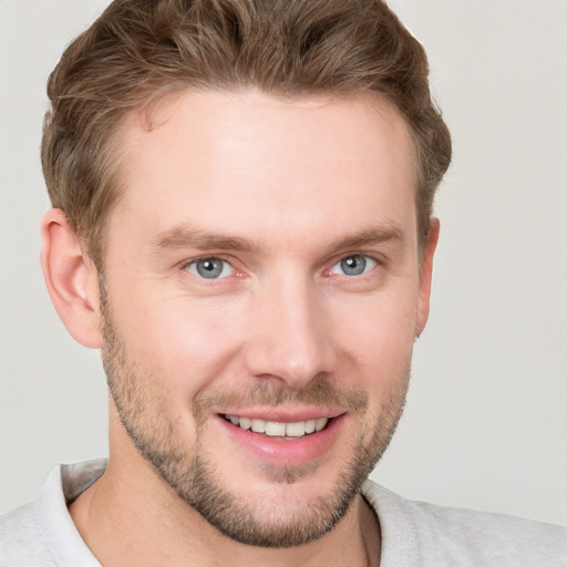 Joyful white young-adult male with short  brown hair and grey eyes