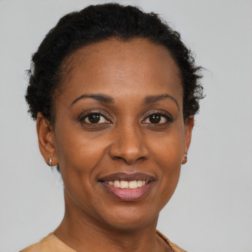 Joyful black adult female with short  brown hair and brown eyes