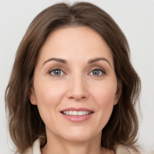 Joyful white young-adult female with medium  brown hair and grey eyes