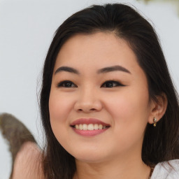 Joyful asian young-adult female with long  brown hair and brown eyes