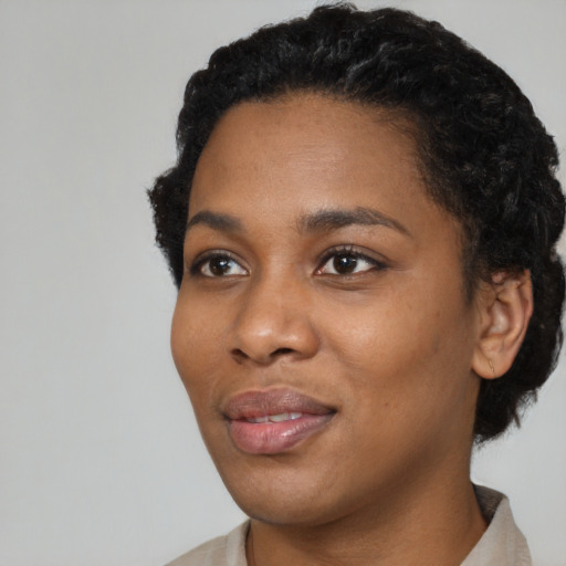 Joyful black young-adult female with short  black hair and brown eyes