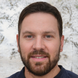 Joyful white adult male with short  brown hair and brown eyes