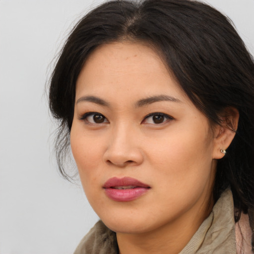 Joyful asian young-adult female with long  brown hair and brown eyes