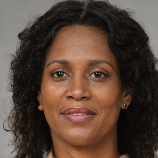 Joyful black adult female with long  brown hair and brown eyes