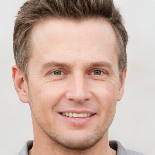 Joyful white adult male with short  brown hair and grey eyes