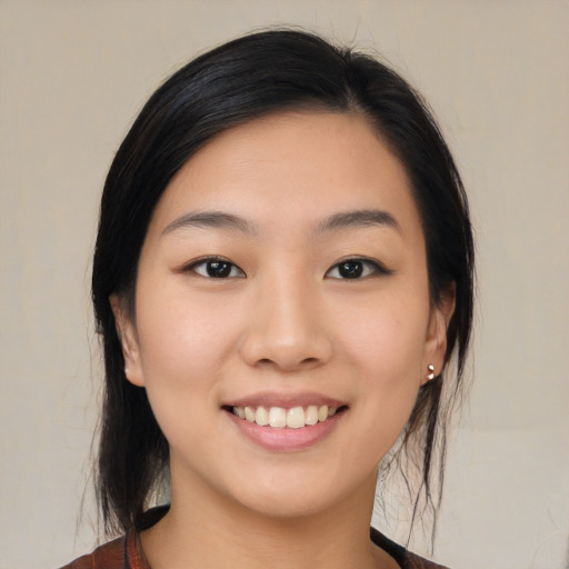 Joyful asian young-adult female with medium  black hair and brown eyes