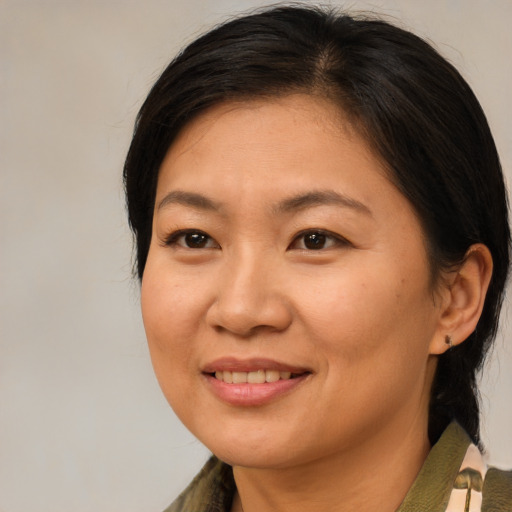 Joyful asian adult female with medium  brown hair and brown eyes