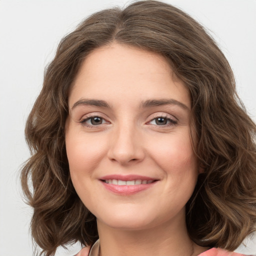 Joyful white young-adult female with long  brown hair and green eyes