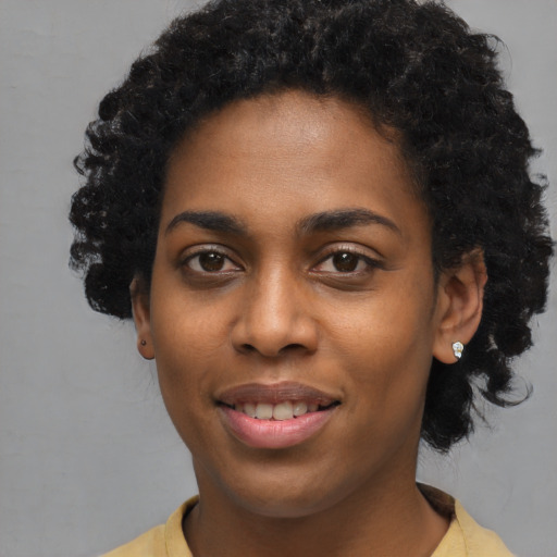 Joyful black young-adult female with short  black hair and brown eyes