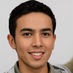 Joyful latino young-adult male with short  brown hair and brown eyes