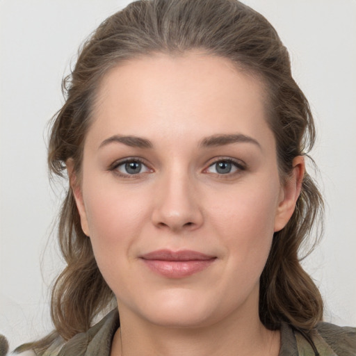 Joyful white young-adult female with medium  brown hair and grey eyes