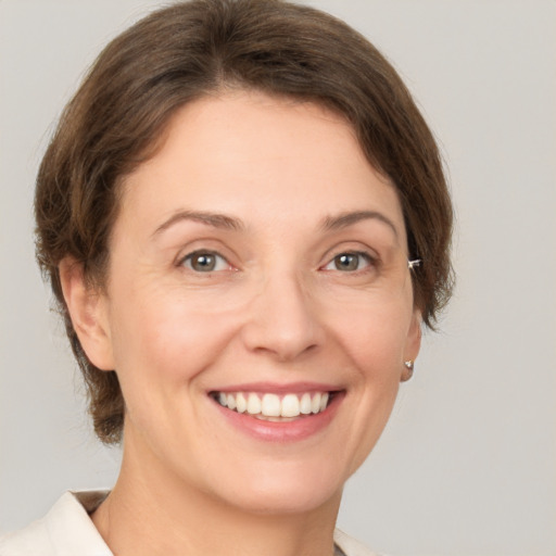 Joyful white young-adult female with medium  brown hair and green eyes