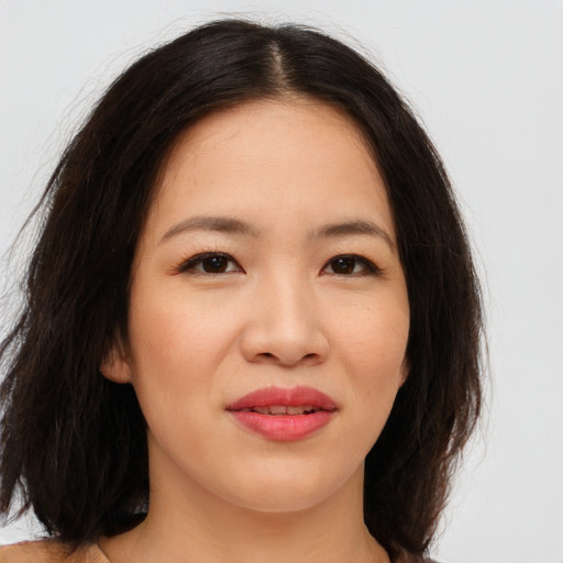 Joyful asian young-adult female with long  brown hair and brown eyes
