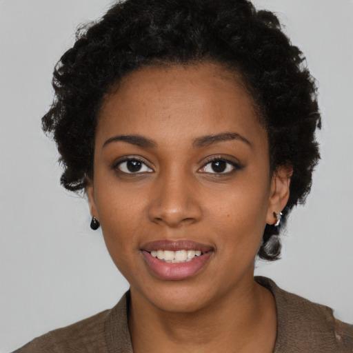 Joyful black young-adult female with short  black hair and brown eyes