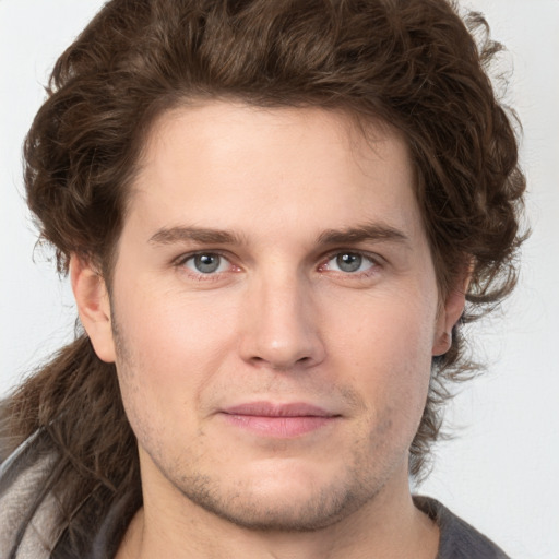 Joyful white young-adult male with medium  brown hair and grey eyes