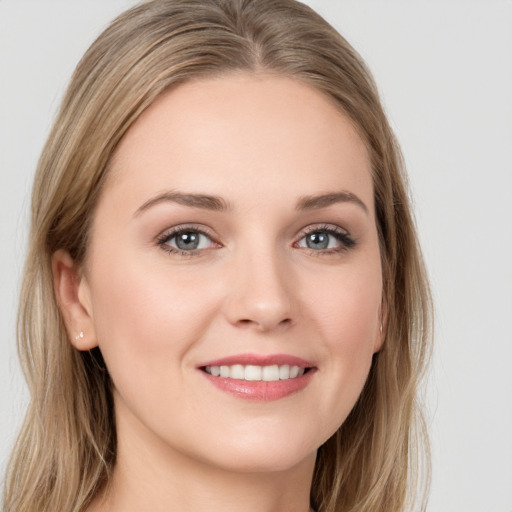 Joyful white young-adult female with long  brown hair and blue eyes