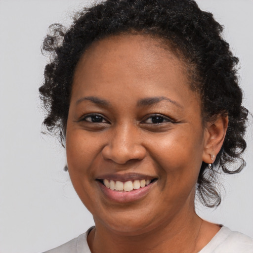 Joyful black young-adult female with medium  brown hair and brown eyes