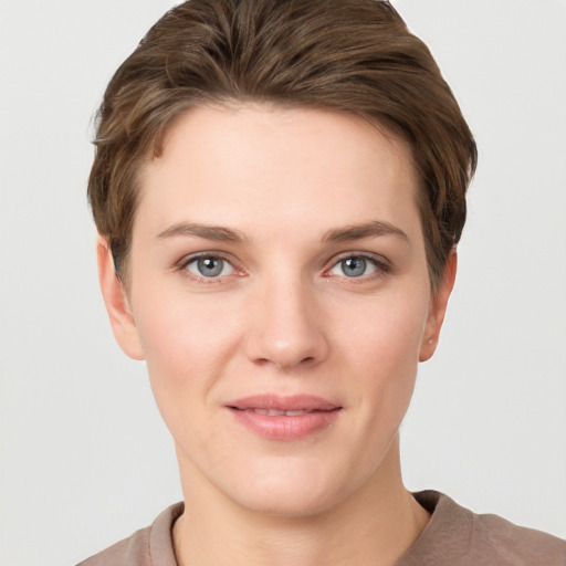 Joyful white young-adult female with short  brown hair and grey eyes