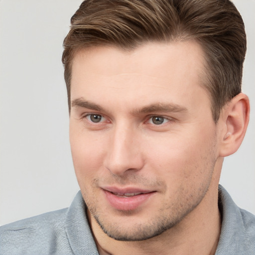 Joyful white young-adult male with short  brown hair and grey eyes