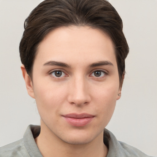 Joyful white young-adult female with short  brown hair and grey eyes