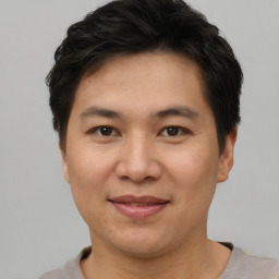 Joyful asian young-adult male with short  brown hair and brown eyes