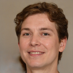 Joyful white adult male with medium  brown hair and brown eyes