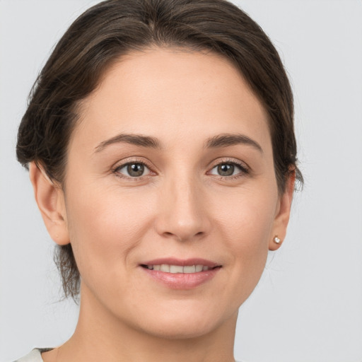 Joyful white young-adult female with medium  brown hair and grey eyes