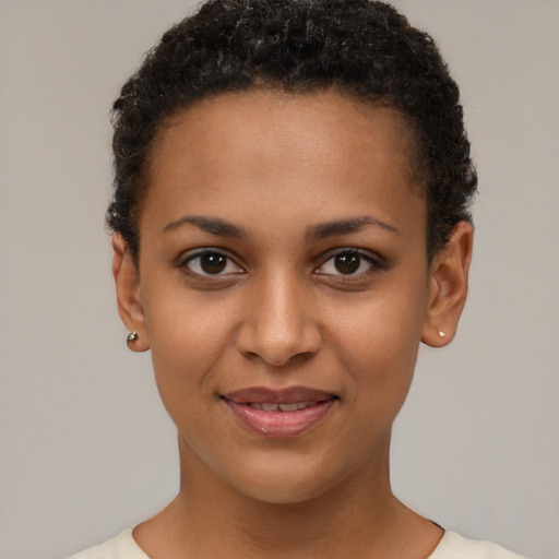 Joyful black young-adult female with short  brown hair and brown eyes