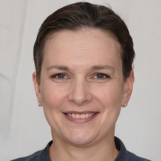 Joyful white adult female with short  brown hair and grey eyes