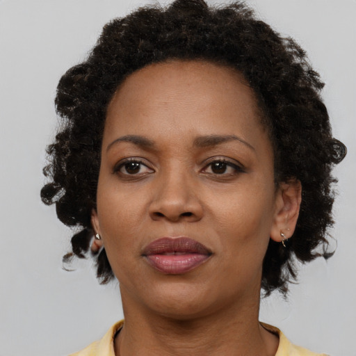 Joyful black adult female with short  brown hair and brown eyes