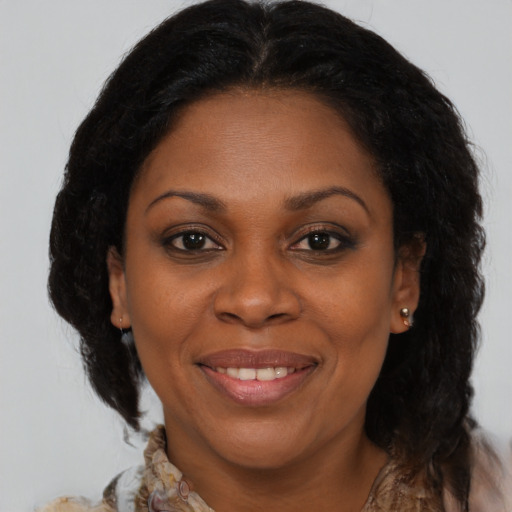 Joyful black adult female with medium  brown hair and brown eyes