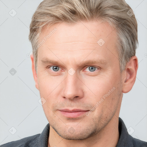 Joyful white adult male with short  brown hair and grey eyes