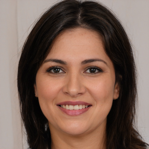 Joyful white young-adult female with long  brown hair and brown eyes