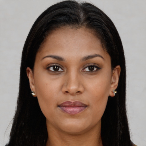 Joyful black young-adult female with long  brown hair and brown eyes