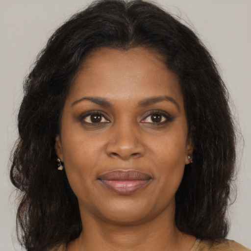 Joyful black young-adult female with long  brown hair and brown eyes
