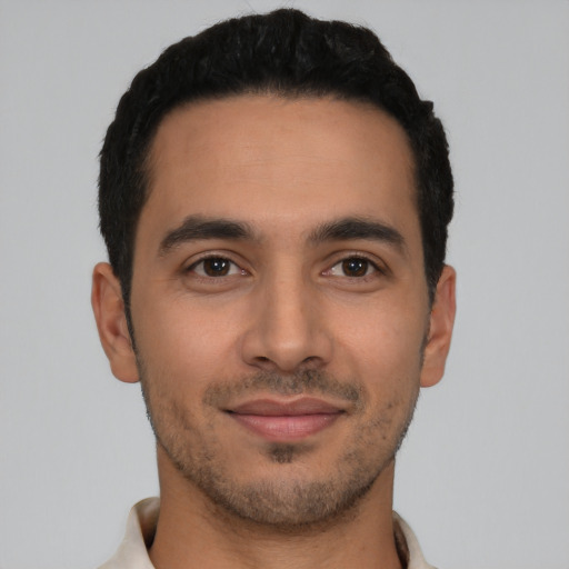 Joyful latino young-adult male with short  black hair and brown eyes