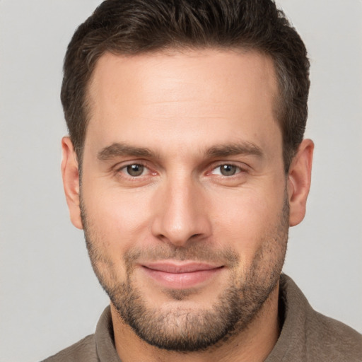 Joyful white young-adult male with short  brown hair and brown eyes