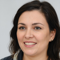 Joyful white adult female with medium  brown hair and brown eyes