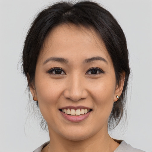 Joyful asian young-adult female with medium  brown hair and brown eyes
