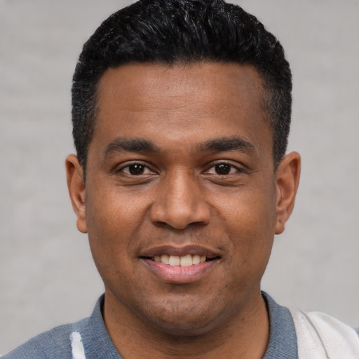 Joyful latino young-adult male with short  black hair and brown eyes