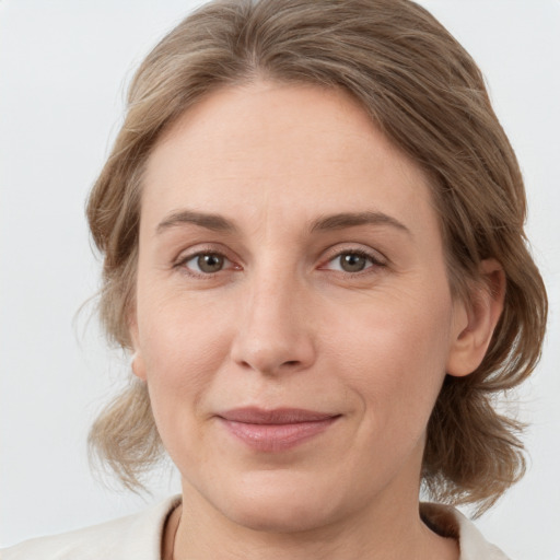 Joyful white adult female with medium  brown hair and grey eyes