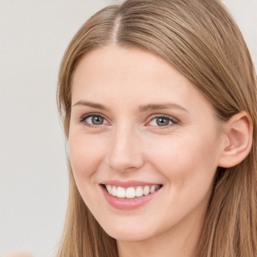 Joyful white young-adult female with long  brown hair and grey eyes