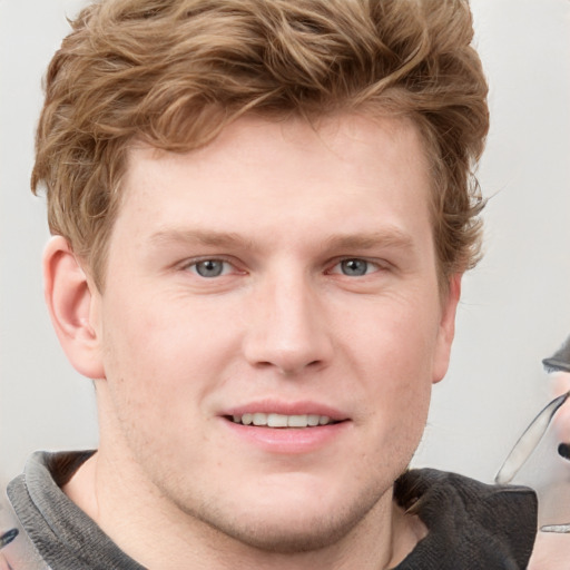 Joyful white young-adult male with short  brown hair and blue eyes