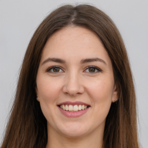 Joyful white young-adult female with long  brown hair and brown eyes