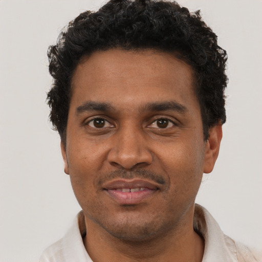 Joyful black young-adult male with short  black hair and brown eyes